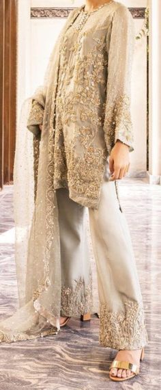 This enchanting and charming outfit is lavishly hand embellished in mason green organza, with beautiful intricate motifs that makes it an ideal outfit for any event. Paired with an elegant raw silk bell-bottom and embellished dupatta scalloped from all four sides. Color: Gray Includes: Shirt Bottom Duppata Elegant Hand Embellished Salwar Kameez For Reception, Elegant Hand-embellished Salwar Kameez For Reception, Elegant Embroidered Raw Silk Sharara, Elegant Embroidered Organza Lehenga, Glamorous Embroidered Organza Sets, Party Wear Organza Salwar Kameez Hand Embellished, Party Wear Hand Embellished Organza Salwar Kameez, Green Elegant Salwar Kameez For Reception, Elegant Green Salwar Kameez For Reception