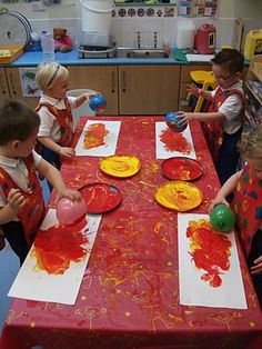 children at a table with paper plates and balloons