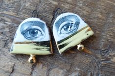 two pairs of earrings with an eye painted on them