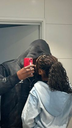 a woman taking a selfie with her cell phone in front of a man's face