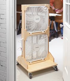 two fans sitting on top of each other in front of a man standing next to an open door