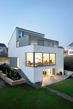 a modern house is lit up at night