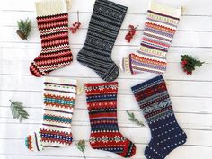 knitted christmas stockings laid out on a white wooden surface