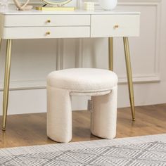 a white dressing table with a mirror and stool