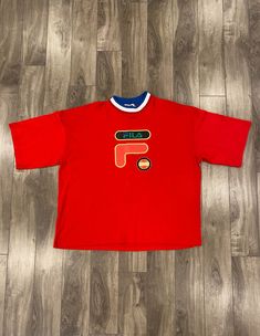 Description: 90s Fila Italy tee Flaws: Small mark above embroidery, please see pictures. Size: Tagged XL, Fits 2XL Length: 26.5" Pit to Pit: 26" Sleeve: 10" Brand: Fila Era: 90s Color: Red Store Item #IN992 Red Crew Neck T-shirt With Embroidered Logo, 90s Crew Neck Top With Embroidered Logo, Red Top With Embroidered Logo For Streetwear, Red T-shirt With Embroidered Logo For Streetwear, Red Crew Neck Top With Embroidered Logo, Sporty Red Tops With Embroidered Logo, Red Tops With Embroidered Graphics For Streetwear, Red Embroidered Streetwear Tops, Red Short Sleeve Top With Embroidered Graphics