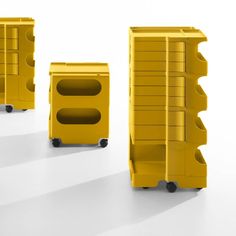 three yellow plastic storage containers sitting on top of each other in front of a white background