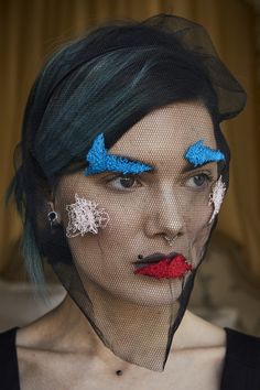 a woman with green hair and blue eyes has her face painted red, white and blue