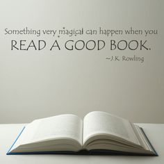 an open book sitting on top of a table next to a wall with a quote