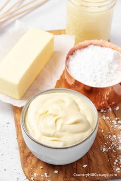 ingredients for making cheesecakes on a cutting board including butter, sugar and flour