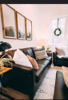 a living room with couches, chairs and pictures on the wall in front of them