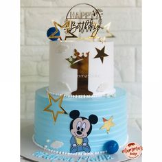 a blue and white birthday cake with mickey mouse on top