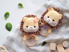 two crocheted lion toys sitting next to each other on top of a blanket