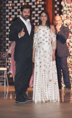 the newly married couple pose for a photo in front of an elaborately decorated backdrop