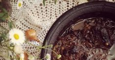 a pot filled with food sitting on top of a doily covered table next to flowers