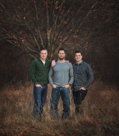 three men standing in front of a tree