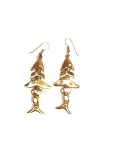 These vintage Anne Klein articulated fish skeleton earrings are absolutely fantastic! Dating to the 1980s, they are a matte, brushed-gold, and are truly a delight to wear. Almost brushing the shoulder, these sleek and modern earrings are eye-catching and elegant. As with all Anne Klein jewelry from this era, these are extremely high-quality and beautifully made. Gold-plated brass  Total length: 3in. (7.62cm.) Width: just over 1in. (2.54cm.) Made in U.S.A  Signed AK on back These earrings are in Articulated Fish, Fish Skeleton, Skeleton Earrings, Fish Bone, Modern Earrings, Brushing, Antique Items, Anne Klein, Skeleton