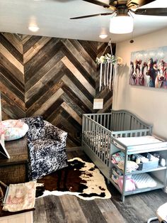 a baby's room with a chevron wood wall