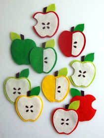 felt apple appliques are arranged on a white surface with green and red apples