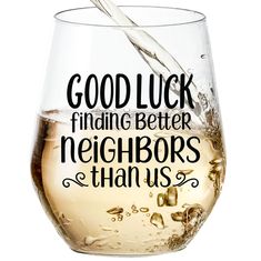 a wine glass filled with white wine being poured into it that says, good luck finding better neighbors than us