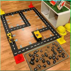 a play area with cars and blocks on the floor