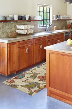 a kitchen filled with lots of wooden cabinets and counter top space next to a window