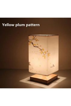 a lamp that is sitting on top of a wooden stand with the words yellow plum pattern