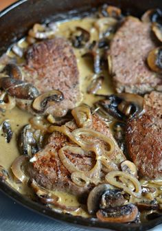 some meat and mushrooms are cooking in a skillet