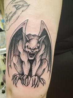 a black and white tattoo with a bat on it's arm that has claws in the shape of a demon