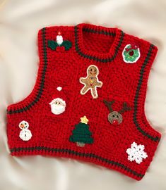 a red knitted sweater with christmas decorations on it