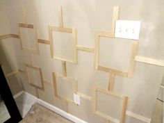 a bathroom wall that is being constructed with wood strips and tape on the wall to make it look like they have been taped together