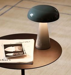 a lamp sitting on top of a table next to a magazine