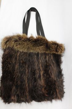 "RACCOON FUR TOTE STYLE BAG!  THIS ITEM IS SCRAP: THE FUR IS RIPPED BUT THE GOOD PART CAN BE USED FOR FUR ACCESSORY PROJECET! MEASUREMENT: SIZE 14\"(HEIGHT) X 14\"(WIDTH)  STRAP LENGTH: 22\" a10169 Oliverfurs 9250 Parc Ave. #204, Montreal, Quebec, H2N 1Z2, Canada www.oliverfurswholesale.com oliver@oliverfurswholesale.com Toll free: 1-866-845-9997 International: 1-514-845-9997" Brown Rectangular Bag With Faux Fur Lining, Brown Shopping Bag With Faux Fur Lining, Brown Bag With Faux Fur Lining For Shopping, Faux Fur Lined Tote Bag, Shopping Bags With Faux Fur Lining, Brown Faux Fur Lined Tote Shoulder Bag, Brown Tote Shoulder Bag With Faux Fur Lining, Travel Tote Bag With Faux Fur Lining, Everyday Tote Bag With Faux Fur Lining