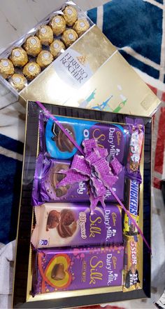 an assortment of chocolates and candy in a gift box on top of a table