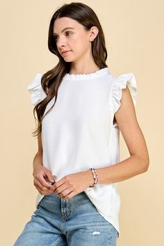 The Emory Sage Top is a stylish everyday top that offers versatility and comfort. It features solid short ruffled sleeves and a high neckline with ruffles that add a touch of elegance to the design. Perfect for any occasion, this top is sure to be a staple in your wardrobe! 100% Rayon Chic Solid Color Blouse With Ruffle Sleeves, Ruffle Sleeve Tops With Ruffles For Brunch, Brunch Tops With Ruffle Hem And Ruffled Collar, Chic Ruffled Short Sleeve Tops, Chic Solid Color Blouse With Flutter Sleeves, White Blouse With Ruffle Hem And Sleeves, Chic Short Sleeve Ruffled Top, Chic Short Sleeve Tops With Ruffles, Elegant Stretch Tops With Flutter Sleeves