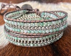 "This is our fun and new 2-wrap bracelet. The stones are 3mm faceted green aventurine and are accented with a rhodium chain sewn down the middle of the stones on distressed gray leather. It measures 13.5\" to 15.5\" and uses a button and 2 loops for closure. The contrast of the chain, the leather and the stones is artistic and eye catching. It can also be worn as a choker or boot jewelry wrapped one time around your boot. This wrap will be shipped in a Wrapped to Wear jute gift bag." Green Adjustable Wrap Bracelet For Healing, Adjustable Green Wrap Bracelet With Gemstone Beads, Adjustable Green Gemstone Beads Wrap Bracelet, Adjustable Hand Wrapped Aventurine Jewelry, Boot Jewelry, Gray Leather, Green Aventurine, Grey Leather, Chain Bracelet