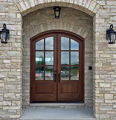 the front entrance to a home with two double doors and brick pillars on either side