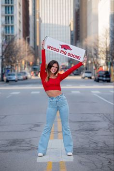 a woman is holding up a sign on the street