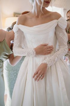 a woman in a white wedding dress getting dressed