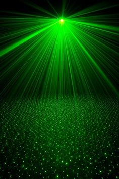 a green light shines brightly over a black background with small white dots on the floor