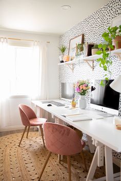 a desk with two chairs and a computer on it