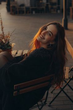 a woman sitting in a chair smiling at the camera