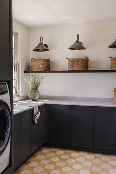 a washer and dryer in a small room with shelves above the washer