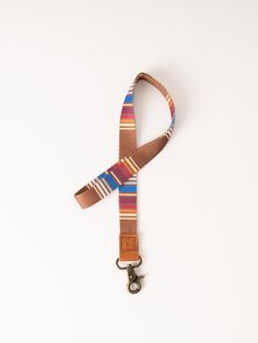 The Sycamore Neck Lanyard is a hands-free way to keep your essentials secure and convenient. This lanyard is designed to be stylish and functional, made with durable materials for easy carrying wherever you go. Sold individually. Size: 17" x 3/4". Materials: Polyester strap, genuine leather loop, and metal clasp. Casual Lanyards With Key Leash For Everyday Use, Casual Lanyard With Key Leash For Everyday Use, Casual Lanyards With Key Leash, Multicolor Key Leash Lanyard For Everyday Use, Adjustable Lanyard With Key Clip For Travel, Multicolor Lanyard With Key Leash For Everyday Use, Adjustable Lanyards With Key Clip For Travel, Adjustable Badge Holder With Swivel Clip For Everyday, Multicolor Lanyards With Key Clip For Everyday Use