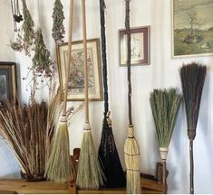 there are many brooms on the shelf in this room and one is hanging from the wall