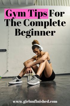 a woman sitting on the floor with headphones in her ears and text gym tips for the complete beginner