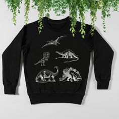 Like my designs but looking for something new? Message me to create a custom creation! Otherwise... enjoy this beautiful graphic dinosaur sweatshirt. Ideal for any situation, a unisex heavy blend crewneck sweatshirt is pure comfort. These garments are made from polyester and cotton. This combination helps designs come out looking fresh and beautiful. The collar is ribbed knit, so it retains its shape even after washing. There are no itchy side seams on these sweaters.  .: 50% cotton, 50% polyester .: Medium-heavy fabric (8.0 oz/yd² (271.25 g/m .: Loose fit .: Sewn-in label .: Runs true to size Unisex Dinosaur Print Crew Neck Top, Winter Dinosaur Print Crew Neck Top, Black Dinosaur Print Crew Neck Top, Casual Dinosaur Print Crew Neck Sweatshirt, White Long Sleeve Dinosaur Print Top, White Long Sleeve Top With Dinosaur Print, Dino Sweater, Dinosaur Sweatshirt, Sweatshirt Graphic