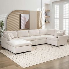 a large white sectional couch sitting on top of a hard wood floored living room