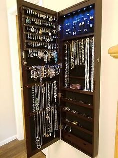 an open jewelry cabinet filled with lots of necklaces