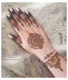 a woman's hand with henna tattoos on it