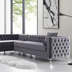 a living room with a gray couch and white rug